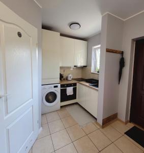 a kitchen with a washing machine and a washer at Apartament na Frezjowej in Gdańsk +3 photos