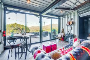 a living room with a couch and a table at Fallbrook Airplane Home with Fire Pit and Mtn Views! in Temecula