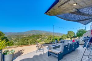 a patio with a blue couch and a chair on a deck at Fallbrook Airplane Home with Fire Pit and Mtn Views! in Temecula +16 photos