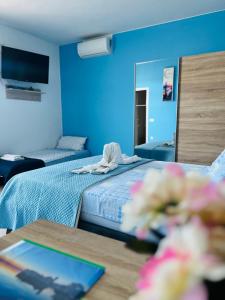 ein blaues Zimmer mit einem Bett, einem Tisch und einem Spiegel in der Unterkunft Apartments Kristal in Kaštela