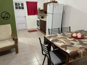 a kitchen with a table and a white refrigerator at departamento nicolay in Junín
