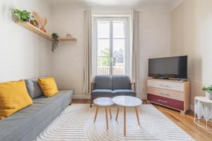 a living room with a couch and a tv at Centre - Parking - Cathédrale in Reims