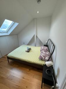 ein Schlafzimmer mit einem Bett in einem Zimmer mit Fenster in der Unterkunft Lovely flat in Brockley, SE4 in London