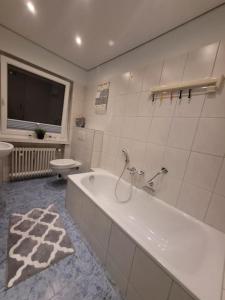 ein weißes Badezimmer mit Badewanne und Toilette in der Unterkunft Ferienwohnung Zum Märchenwald in Hessisch Lichtenau