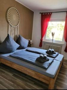 ein Schlafzimmer mit einem Bett mit blauen Laken und einem Fenster in der Unterkunft Ferienwohnung Zum Märchenwald in Hessisch Lichtenau