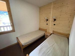 une petite chambre avec deux lits et une fenêtre dans l'établissement Résidence Cristallin - Le Cristallin 43 - Agréable 2 pièces offrant une magnifique vue MAE-5184, à Valmorel