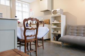 a kitchen with a table and two chairs and a couch at La maisonnette du Prince in Bruges