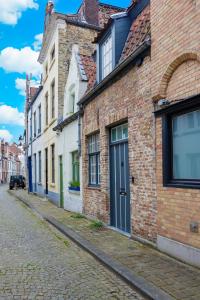 un edificio de ladrillo con una puerta azul en una calle en La maisonnette du Prince, en Brujas