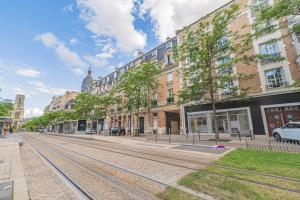 an empty city street with buildings and train tracks at Centre - Parking - Cathédrale in Reims