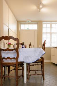 Una cocina con una mesa con un mantel azul y blanco encima. en La maisonnette du Prince, en Brujas 12 fotos más