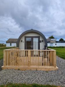 un cane che si trova su un ponte di legno di fronte a una casetta di Easkey Glamping Village a Easkey