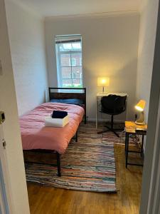 a bedroom with a bed and a desk and a window at South London Double Room in Sutton