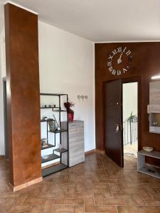 a room with a clock on the wall and a door at Theo House in Siena