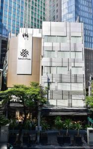 a tall building with a sign on the side of it at Sukhumvit Suites Hotel in Bangkok