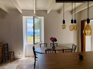 プルバスラネックにあるHavre de paix avec vue imprenable sur la merのテーブルと窓のあるダイニングルーム