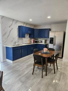 a kitchen with blue cabinets and a table with chairs at Welcome to our Cozy Apartment in Valrico