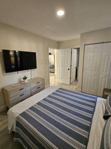 a bedroom with a large bed with a tv on the wall at Welcome to our Cozy Apartment in Valrico +15 photos