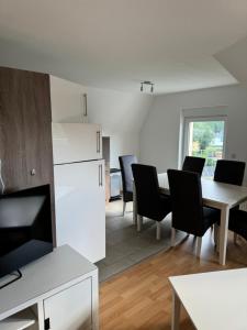 una cucina e una sala da pranzo con tavolo e sedie di Ferienwohnungen Augustusburger Straße 149 a Chemnitz