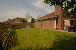 einen Hinterhof eines Hauses mit einem Zaun in der Unterkunft Strandparel 381 in Breskens