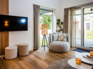 a living room with a chair and a tv at Holiday Home in Voorthuizen near Forest in Voorthuizen