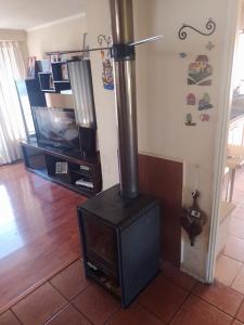 a wood stove in a living room with a tv at Hospedaje Casa Mirador in Puerto Montt