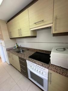 a kitchen with a stove top oven next to a sink at Century in Calpe