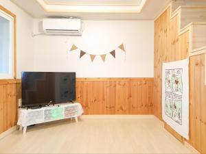 固城郡にある강원 고성ㅡ 숲속오두막 Forest Cabin 잔디마당 독채 바다차량5분 설악산 울산바위の壁に薄型テレビが取り付けられたリビングルーム