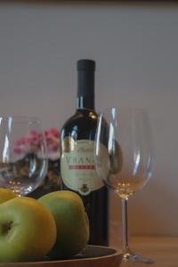 a bottle of wine and two glasses on a table at Zvuk tišine Ostrog in Nikšić