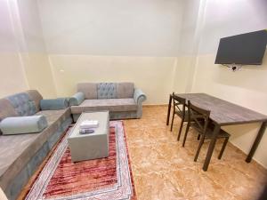 a living room with a couch and a table at فندق الرستاق للشقق الفندقية Al Rustaq Hotel in Ţakham