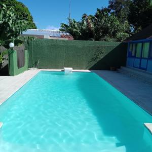 une piscine avec de l'eau bleue dans une cour dans l'établissement Fare MIHIMANA, à Paea