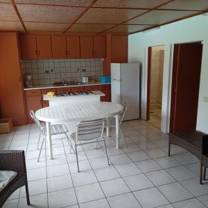 une cuisine avec une table, des chaises et un réfrigérateur dans l'établissement Fare MIHIMANA, à Paea