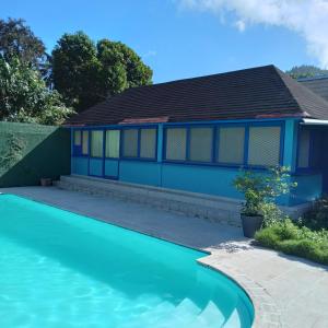une maison bleue avec une piscine en face de celle-ci dans l'établissement Fare MIHIMANA, à Paea