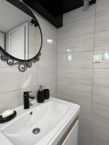 a bathroom with a white sink and a mirror at Zvuk tišine Ostrog in Nikšić +11 photos