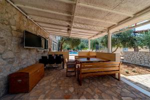 a patio with a ping pong table and a flat screen tv at Olive Grove House in Ston