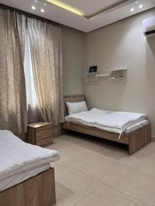 a bedroom with two beds and a window at شقة حي شوران in Al Madinah
