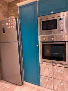 a kitchen with a refrigerator and a microwave at شقة حي شوران in Al Madinah
