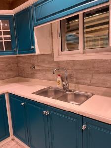a kitchen with blue cabinets and a sink at شقة حي شوران in Al Madinah