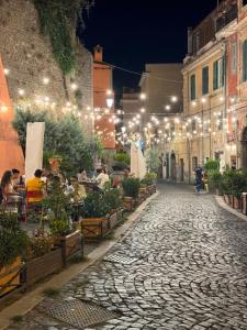 a cobblestone street at night with people sitting at tables at Il Vicoletto Marino in Marino