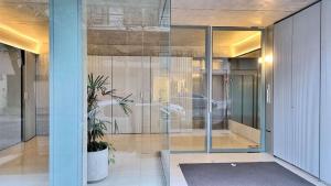 a glass entrance to a building with a potted plant at Magico Palermo in Buenos Aires +21 photos