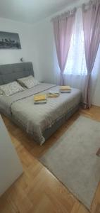 a bedroom with a bed with two pillows on it at Apartman TADEJ & FREE PARKING in Vrnjci