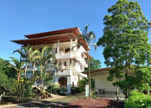 a large white building with trees in front of it at Hotel Twin Galápagos in Puerto Ayora
