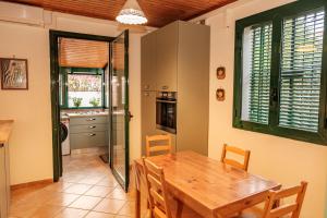 a kitchen and dining room with a wooden table and chairs at La campagna e il mare in Catania