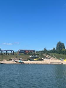 a beach with a group of boats on the water at Nad Sunowem Lake House in Chrzanowo