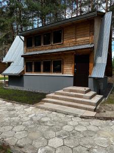 a house with a staircase in front of it at Domki Sosnówka in Majdan Sopocki