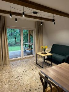 a living room with a green couch and a table at Domki Sosnówka in Majdan Sopocki