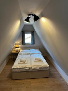 a bedroom with a bed in a attic with a window at Domki Sosnówka in Majdan Sopocki +23 photos