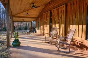 three chairs sitting on the porch of a cabin at Serenity Barn in Mooresville