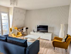 a living room with a couch and a tv at HolidayApartment Val d'Europe in Chessy