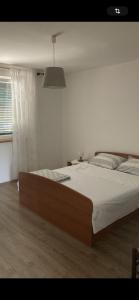 ein Schlafzimmer mit einem großen Bett und einem Fenster in der Unterkunft Giovani in Murter