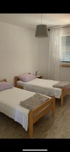 ein Schlafzimmer mit zwei Betten und einem Fenster in der Unterkunft Giovani in Murter